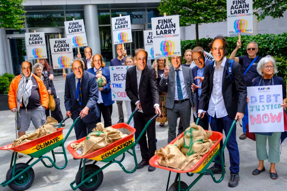 Debt Justice and CAFOD protesters with Larry Fink masks demand BlackRock cancels Ghana's debt, City of London.